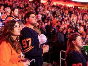 Les fans de hockey chantent l'hymne national alors que les Oilers d'Edmonton affrontent les Blue Jackets de Columbus lors d'un match de la LNH à Rogers Place à Edmonton le 16 décembre 2021.