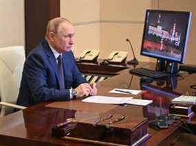 Le président russe Vladimir Poutine assiste à une cérémonie de lever du drapeau sur le ferry maréchal Rokossovsky via une liaison vidéo à la résidence d'État de Novo-Ogaryovo à l'extérieur de Moscou le 4 mars 2022.