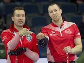 Le capitaine d'Équipe Canada Brendan Bottcher (à gauche) et le troisième Patrick Janssen discutent de stratégie lors du Brier Tim Hortons 2022 à Lethbridge.