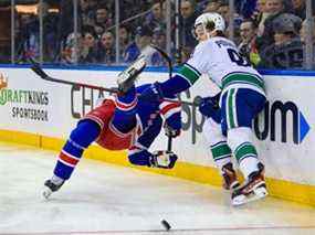 L'ailier droit des Canucks de Vancouver Vasily Podkolzin (92) frappe le défenseur des Rangers de New York Jacob Trouba (8) au cours de la première période au Madison Square Garden.