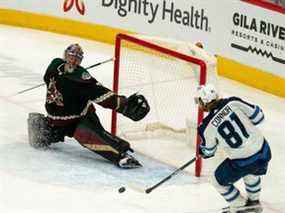 L'ailier gauche des Jets de Winnipeg Kyle Connor (81) marque contre le gardien des Coyotes de l'Arizona Scott Wedgewood (31) au cours de la troisième période au Gila River Arena de Glendale, en Arizona, le 27 février 2022.