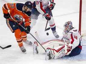 Les Oilers d'Edmonton Warren Foegele (37) se battent pour la rondelle devant les Capitals de Washington Ilya Samsonov (30) lors de la première période d'action de la LNH le mercredi 9 mars 2022 à Edmonton.