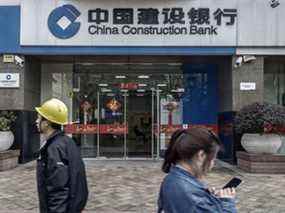 Des piétons passent devant une succursale de la China Construction Bank Corp. à Shanghai, en Chine.