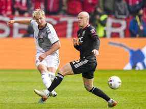 Le défenseur du Toronto FC Lukas MacNaughton (5) déplace le ballon contre DC United.