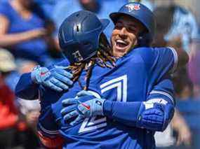 Vladimir Guerrero Jr. des Blue Jays de Toronto embrasse George Springer à l'extérieur de la pirogue après le coup de circuit en solo de Springer lors de la cinquième manche d'un match de baseball d'entraînement de printemps contre les Tigers de Detroit au TD Ballpark, à Dunedin, en Floride, le vendredi 25 mars 2022.