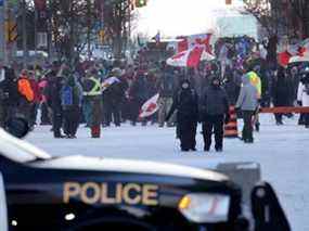 La police surveille les manifestants participant à une manifestation organisée par des camionneurs opposés aux mandats de vaccination qui continuent de se rassembler dans les rues d'Ottawa le 19 février 2022.