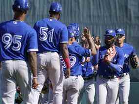 Les joueurs des Blue Jays de Toronto célèbrent leur victoire de 9-5 sur les Orioles de Baltimore lors d'un match de baseball d'entraînement de printemps au stade Ed Smith le vendredi 18 mars 2022, à Sarasota, en Floride. Les Blue Jays ont remporté le match 9-5.