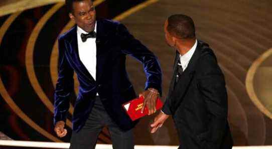 presenter Chris Rock, left, reacts after being hit on stage by Will Smith while presenting the award for best documentary feature at the Oscars on Sunday, March 27, 2022, at the Dolby Theatre in Los Angeles. (AP Photo/Chris Pizzello)