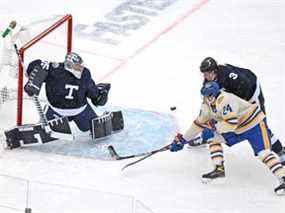 Le gardien de but des Maple Leafs Petr Mrazek effectue un arrêt alors que le défenseur des Leafs Justin Holl couvre Dylan Cozens des Sabres de Buffalo lors de la première période de la Classique Héritage au Tim Hortons Field à Hamilton le dimanche 13 mars 2022.