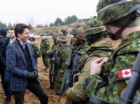 Le premier ministre Justin Trudeau s'entretient avec des soldats lors d'une visite à la base militaire d'Adazi, au nord-est de Riga, en Lettonie, le 8 mars 2022.