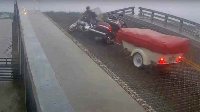 Un motard s’envole presque du pont-levis surélevé après avoir franchi la porte