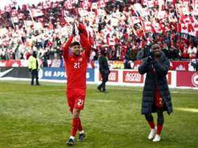 Jonathan Osorio # 21 et Richie Laryea # 22 du Canada célèbrent après le coup de sifflet final après un match de qualification pour la Coupe du monde 2022 contre la Jamaïque au BMO Field le 27 mars 2022 à Toronto, Ontario, Canada.