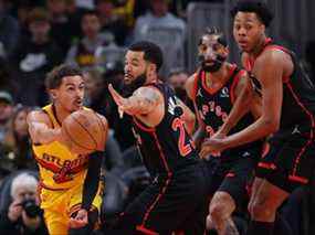 Trae Young des Atlanta Hawks passe le ballon contre Fred VanVleet et Scottie Barnes des Raptors de Toronto samedi soir.