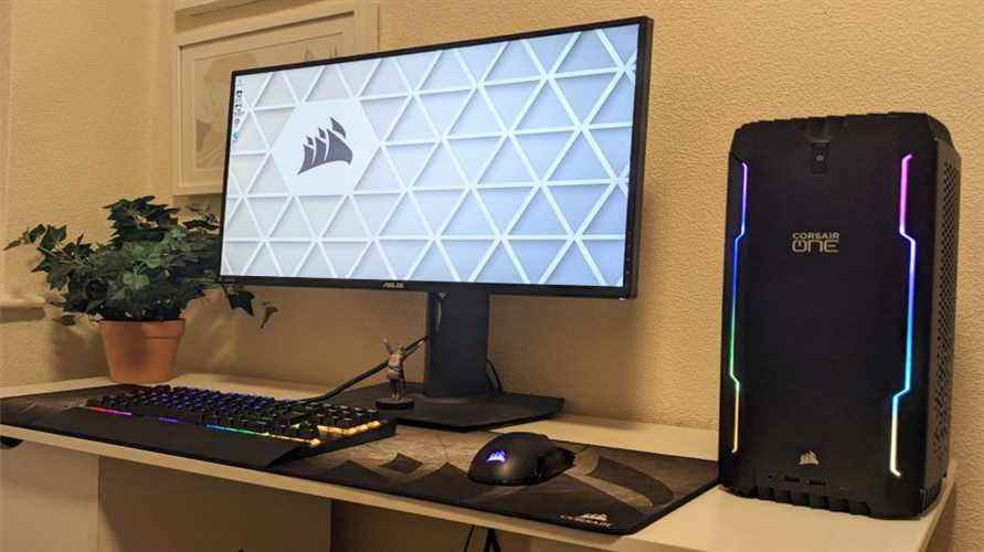 Un PC de jeu Corsair One i300 se trouve à droite d'un moniteur de jeu et d'autres périphériques Corsair