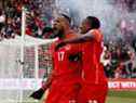 Le Canadien Cyle Larin (17 ans) célèbre un but avec Richie Laryea (22 ans) lors d'un match de qualification pour la Coupe du monde de la FIFA contre la Jamaïque au BMO Field de Toronto, en Ontario, le 27 mars 2022.