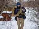 Le photographe ukrainien Maksim Levin porte un chat près de la ligne de séparation des séparatistes soutenus par la Russie dans la région de Donetsk, en Ukraine, le 25 janvier 2022. 