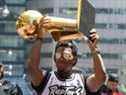 Le garde des Raptors Kyle Lowry montre le trophée Larry O'Brien aux fans lors d'un défilé dans le centre-ville de Toronto pour célébrer leur titre NBA.