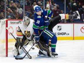 Alex Chiasson (39 ans) des Canucks de Vancouver est contrôlé par Shea Theodore des Golden Knights de Vegas, de retour, alors qu'il tente de rediriger la rondelle devant le gardien de but Robin Lehner, à gauche, au cours de la troisième période d'un match de hockey de la LNH à Vancouver, C.-B., dimanche 3 avril 2022.