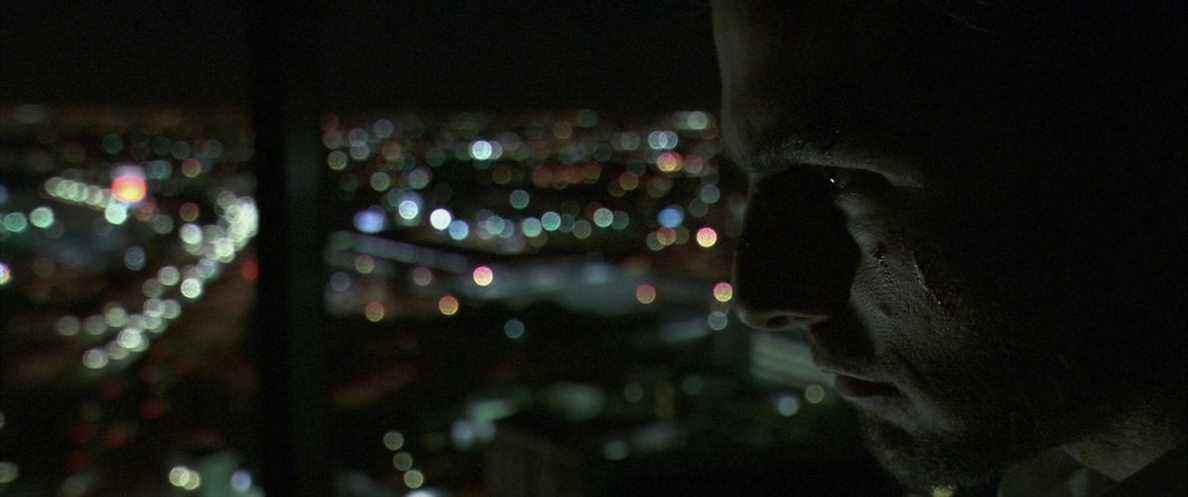 Tom Cruise regarde d'un air menaçant la ligne d'horizon de Los Angeles dans Collateral.
