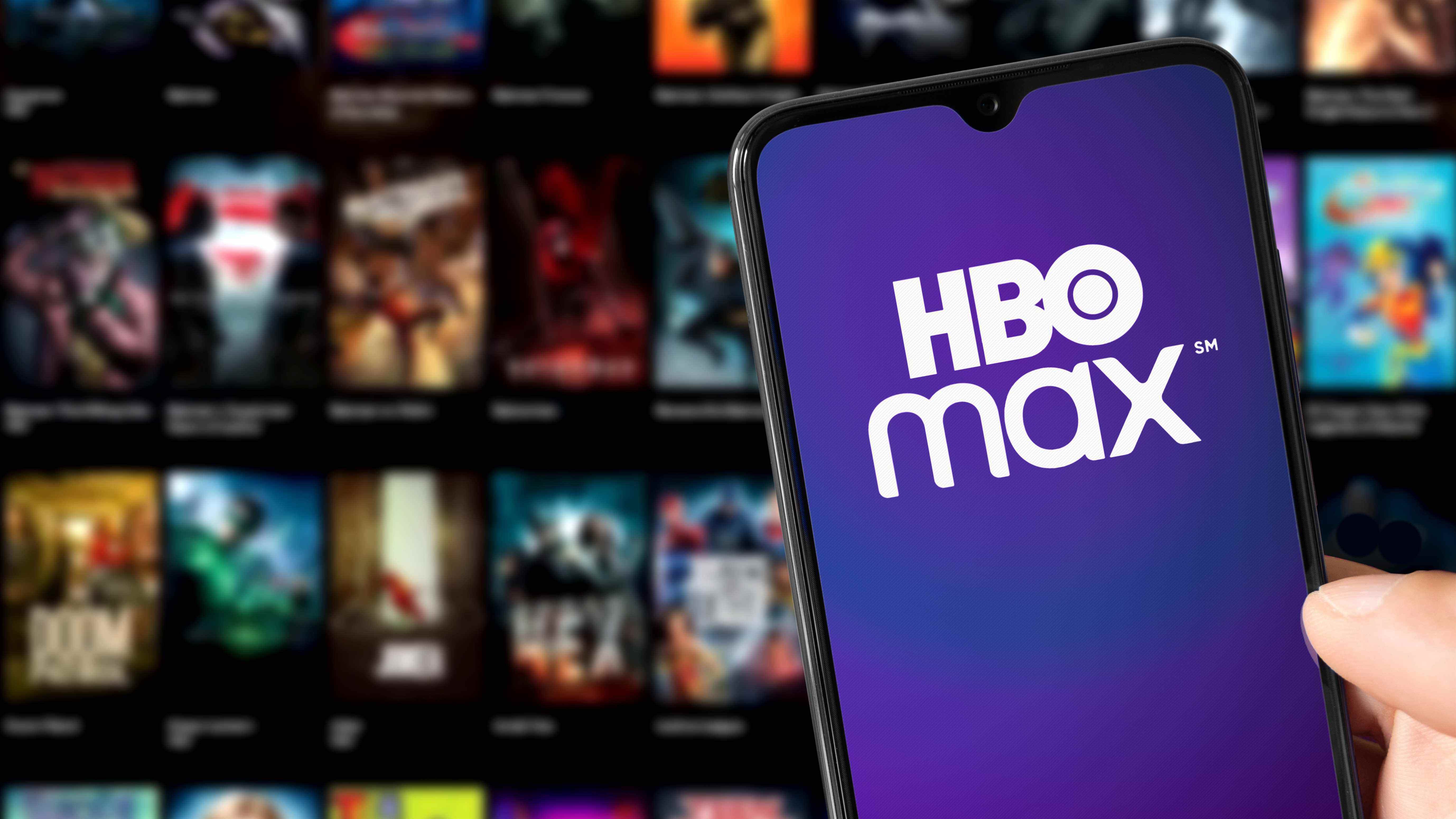 Le logo HBO Max sur un téléphone devant un écran d'affiches