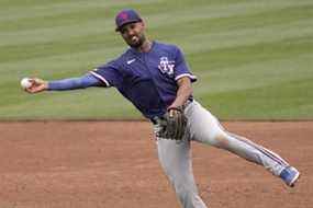 L'arrêt-court des Texas Rangers Marcus Semien lance au premier trop tard pour sortir sur un seul coup sûr de JP Crawford des Mariners de Seattle lors de la troisième manche d'un match de baseball d'entraînement de printemps le lundi 28 mars 2022 à Peoria, en Arizona.