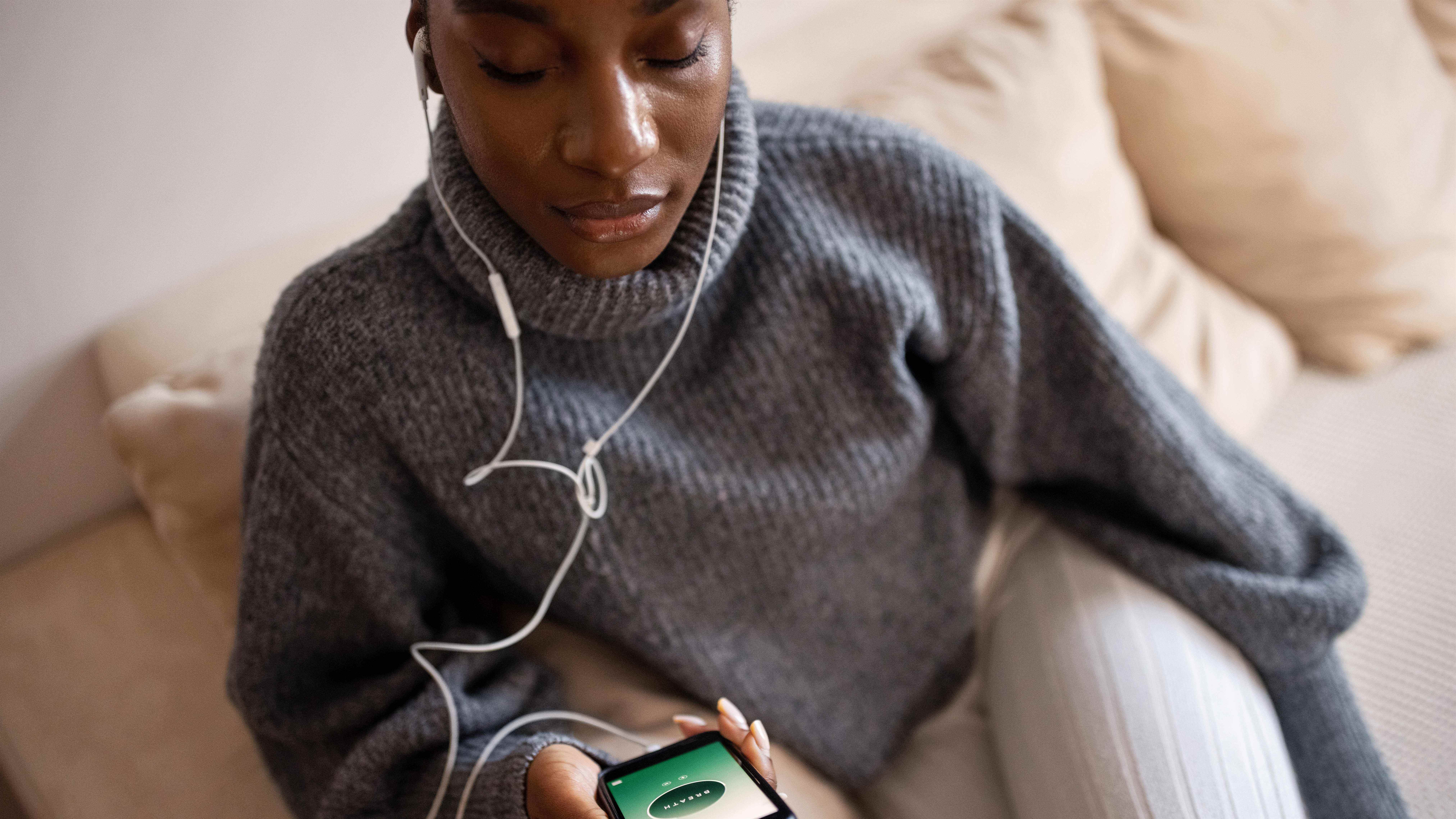 Jeune femme respirant profondément avec l'application ouverte sur le téléphone