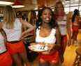 Hooters Girl Charmaine Fobbs (C) est suivie par l'entraîneur de formation Trisha Robinson (R) alors que le personnel du restaurant Hooters se prépare pour l'ouverture du premier Hooters Casino Hotel au monde à Las Vegas, Nevada.