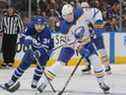 Tage Thompson des Sabres de Buffalo patine avec la rondelle contre Auston Matthews des Maple Leafs de Toronto lors d'un match de la LNH au Scotiabank Arena le 12 avril 2022 à Toronto, Ontario, Canada. 