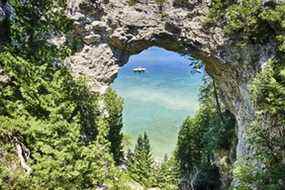 Trois bateaux sur le lac Huron sont amarrés ensemble sous Arch Rock sur l'île Mackinac, au Michigan.