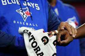 Un entraîneur aide le joueur de premier but des Blue Jays de Toronto Vladimir Guerrero Jr., à droite, qui s'est blessé lors de la deuxième manche du match de baseball de l'équipe contre les Yankees de New York le mercredi 13 avril 2022 à New York.  (AP Photo/Frank Franklin II)