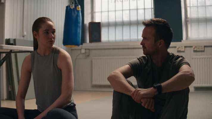 Karen Gillan et Aaron Paul parlent assis par terre dans une scène de Dual.