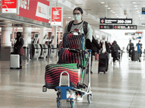 Passagers au niveau des départs presque vide de l'aéroport international Trudeau de Montréal le 17 décembre 2021.