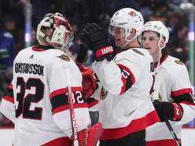 Nick Holden, à droite, des Sénateurs d'Ottawa, et le gardien de but Filip Gustavsson, de Suède, célèbrent après qu'Ottawa a vaincu les Canucks de Vancouver lors d'une fusillade lors d'un match de hockey de la LNH à Vancouver, le mardi 19 avril 2022.