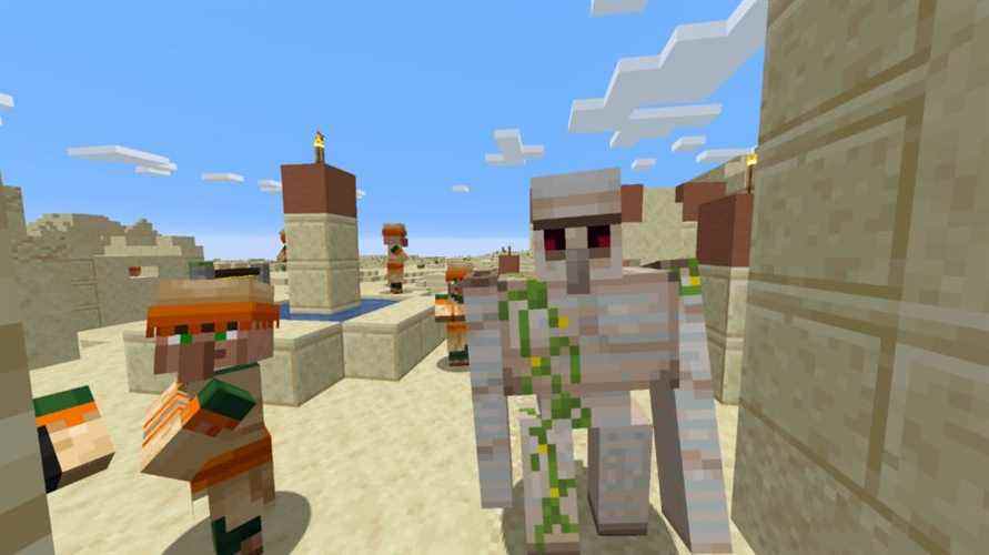 Village Minecraft dans le désert avec un golem de fer et plusieurs villageois