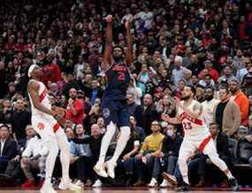 Le garde des Raptors de Toronto Fred VanVleet (23) et l'attaquant Precious Achiuwa (5) regardent le match du centre des 76ers de Philadelphie Joel Embiid (21) remportant trois pointeurs pendant les heures supplémentaires de la première ronde des séries éliminatoires de la NBA à Toronto le mercredi 20 avril 2022. LA PRESSE CANADIENNE/Nathan Dénette