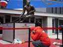 Un homme prend un moment et s'agenouille au pied de la statue de Guy Lafleur à Montréal pour rendre hommage à Lafleur, décédé le 22 avril 2022.