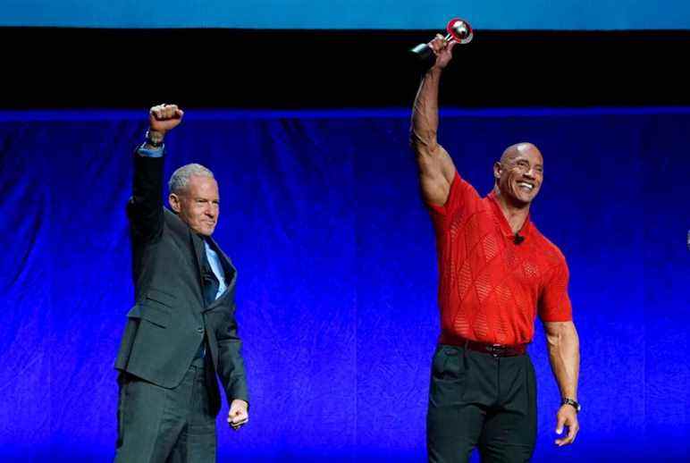 Toby Emmerich, left, chairman of the Warner Bros. Pictures Group, and Dwayne Johnson react to the audience after Emmerich handed Johnson the CinemaCon "Entertainment Icon of the Decade" award during the Warner Bros. Pictures presentation at CinemaCon 2022 at Caesars Palace, Tuesday, April 26, 2022, in Las Vegas. (AP Photo/Chris Pizzello)