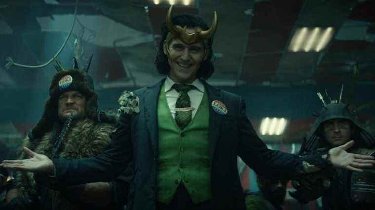 Tom Hiddleston dressed as President Loki with his arms splayed open wide.