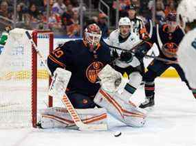 Le gardien de but des Oilers d'Edmonton, Mikko Koskinen (19 ans), arrête Noah Gregor (73 ans) des Sharks de San Jose lors de la deuxième période d'action de la LNH au Rogers Place à Edmonton, le jeudi 28 avril 2022.