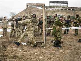 Des sapeurs de combat canadiens et américains font la démonstration des procédures de dégagement des salles aux soldats ukrainiens à Starychi, en Ukraine, en 2017.