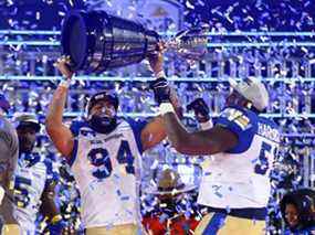 Jackson Jeffcoat # 94 et Jermarcus Hardrick # 51 des Blue Bombers de Winnipeg célèbrent la victoire avec la Coupe Grey après le 108e match de championnat de la Coupe Grey de la LCF contre les Tiger-Cats de Hamilton au Tim Hortons Field le 12 décembre 2021 à Hamilton, Ontario, Canada.