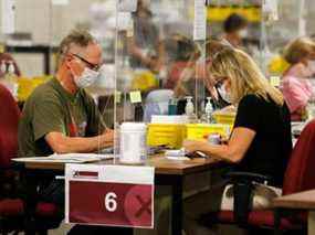 Les agents des bulletins de vote spéciaux comptent les bulletins de vote des électeurs nationaux, internationaux, des Forces canadiennes et des électeurs incarcérés qui ont été reçus par la poste lors de l'élection fédérale à Ottawa, Ontario, Canada, le 20 septembre 2021.