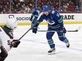 Michael Carcone des Coyotes de l'Arizona regarde Bo Horvat des Canucks de Vancouver grimacer en patinant vers le banc après avoir été touché à la cheville avec la rondelle lors de leur match dans la LNH au Rogers Arena jeudi.  Vancouver a gagné 7-1.