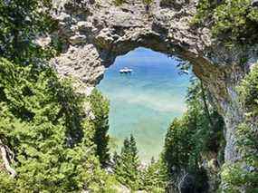 Trois bateaux sur le lac Huron sont amarrés ensemble sous Arch Rock sur l'île Mackinac, au Michigan.