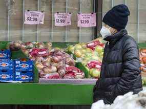 Une personne passe devant des épiceries au supermarché Yao Hua de Toronto sur Gerrard Street East.