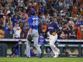 Le plus proche des Blue Jays de Toronto, Jordan Romano, quitte le terrain alors que Jeremy Pena des Astros termine troisième après avoir frappé un coup de circuit lors de la 10e manche au Minute Maid Park dimanche.