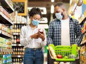 Cette photo montre un couple obéissant aux règles de masquage lors de l'épicerie