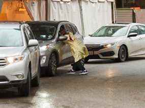 Un travailleur de la santé du Hospital for Sick Children de Toronto se penche sur une voiture dans un centre de test COVID-19 au volant le 5 janvier 2022.