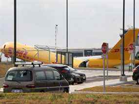 Le personnel de l'aéroport se tient sur les lieux où un avion cargo Boeing 757-200 exploité par DHL a effectué un atterrissage d'urgence avant de déraper de la piste et de se séparer, ont déclaré les autorités de l'aviation, à l'aéroport international Juan Santamaria d'Alajuela, Costa Rica, le 7 avril 2022.