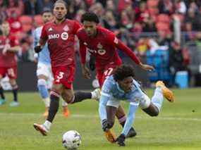 Talles Magno, du New York City FC, à droite, tombe dans la surface de réparation sous un défi de Kosi Thompson, du Toronto FC, au centre, lors de la première mi-temps de l'action de soccer MLS à Toronto, le samedi 2 avril 2022.